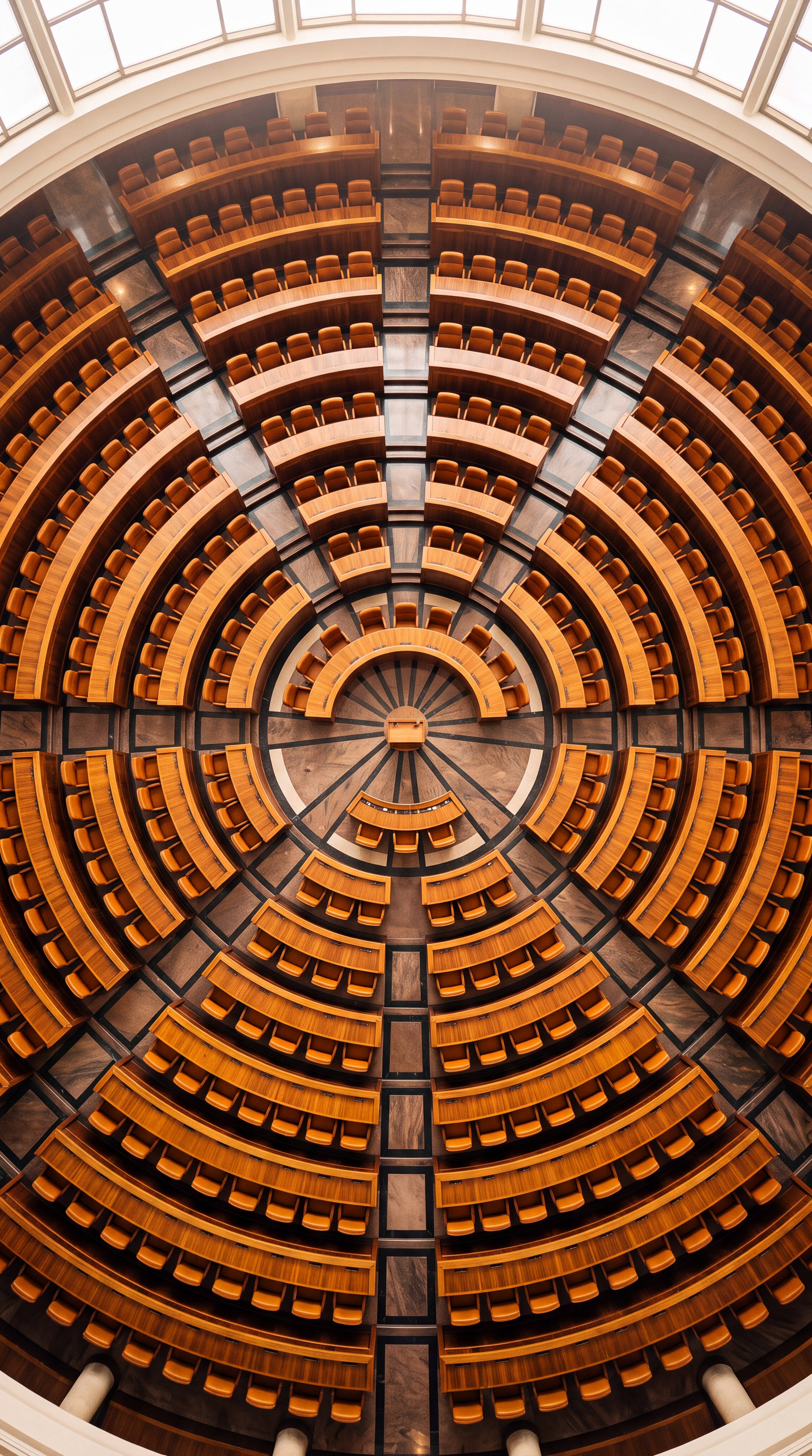 The image shows a circular auditorium with wooden seating arranged in a spiral pattern.
