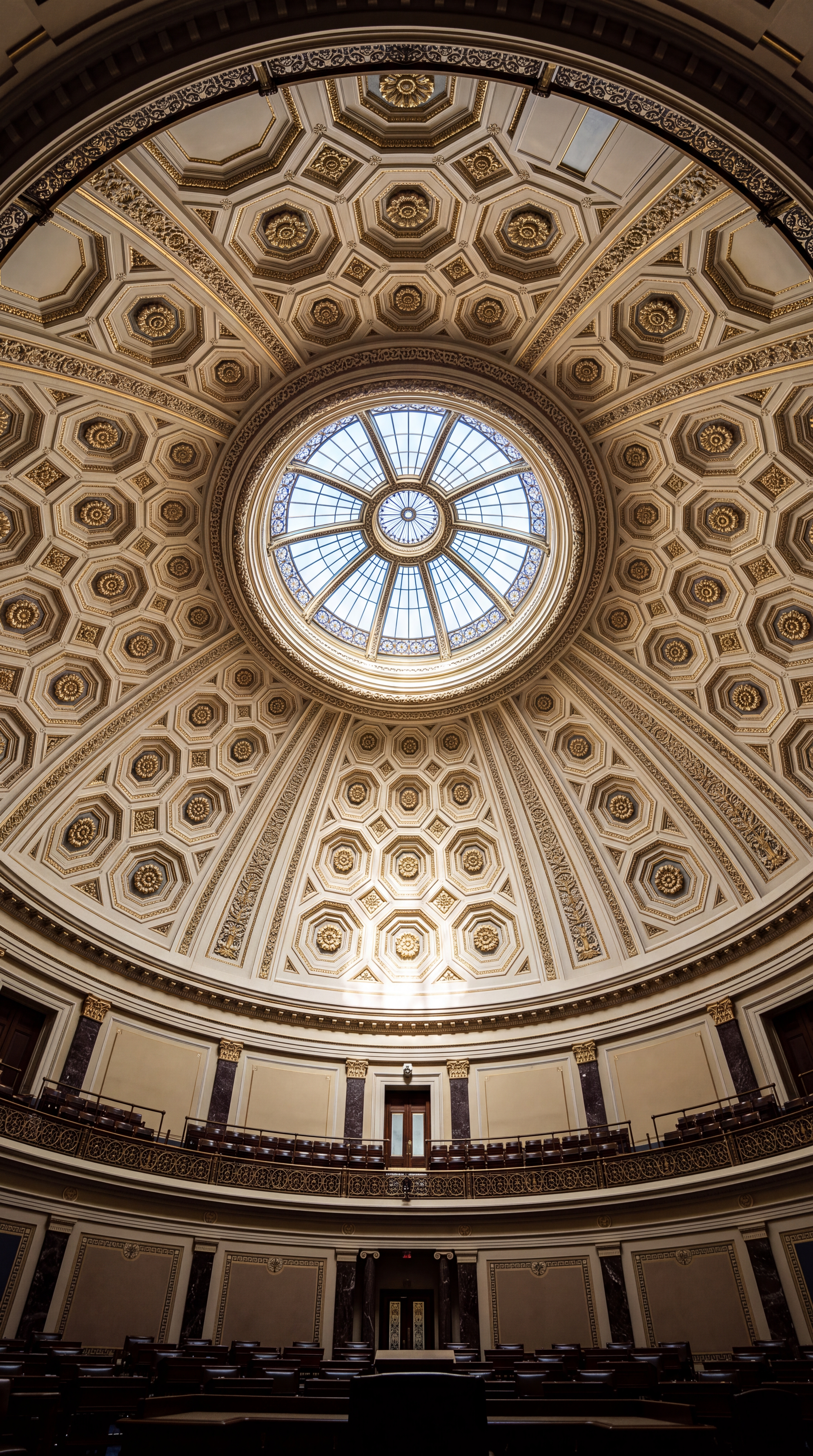 A view of a grand dome with intricate architectural details and a circular skylight.