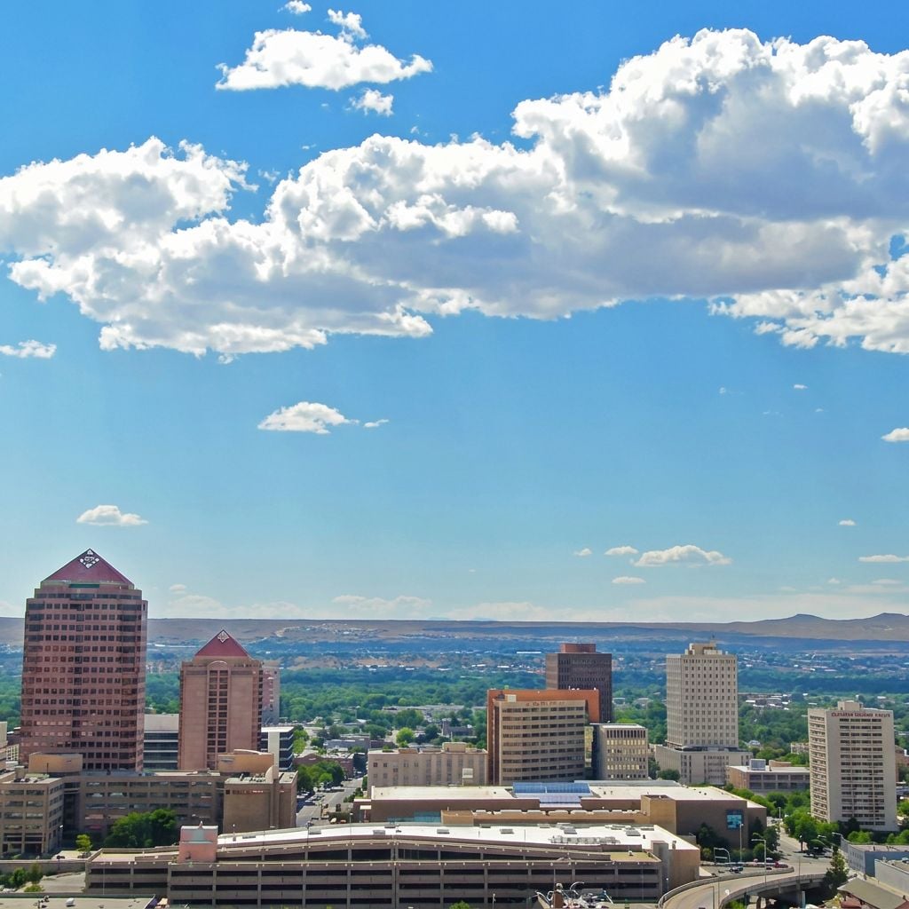 A panoramic view of a city skyline with buildings and a blue sky.