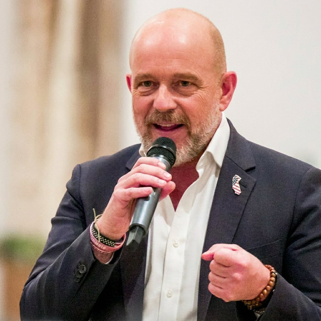 A man speaking into a microphone at an event.