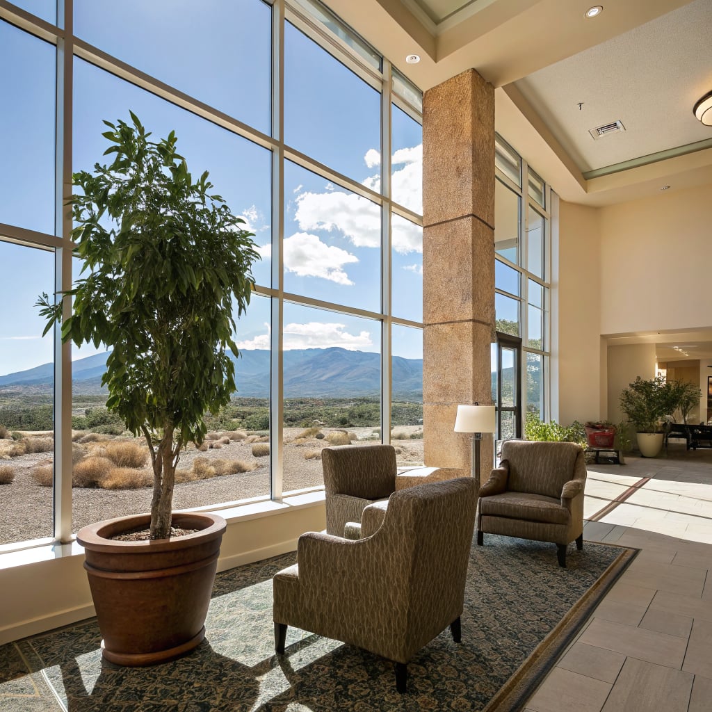 A spacious hotel lobby with large windows showcasing a mountain view.