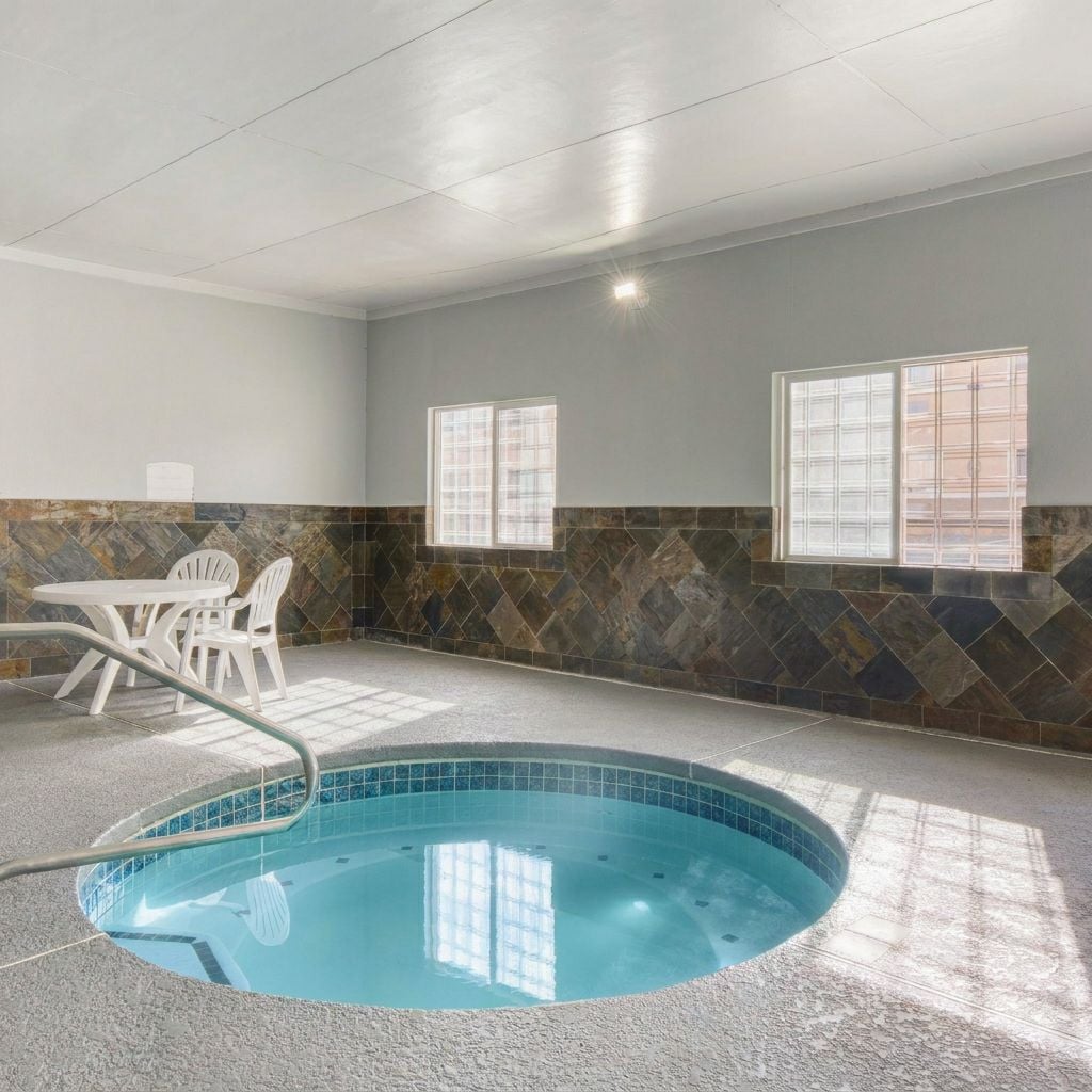 The image shows an indoor hot tub area with a small table and chairs.