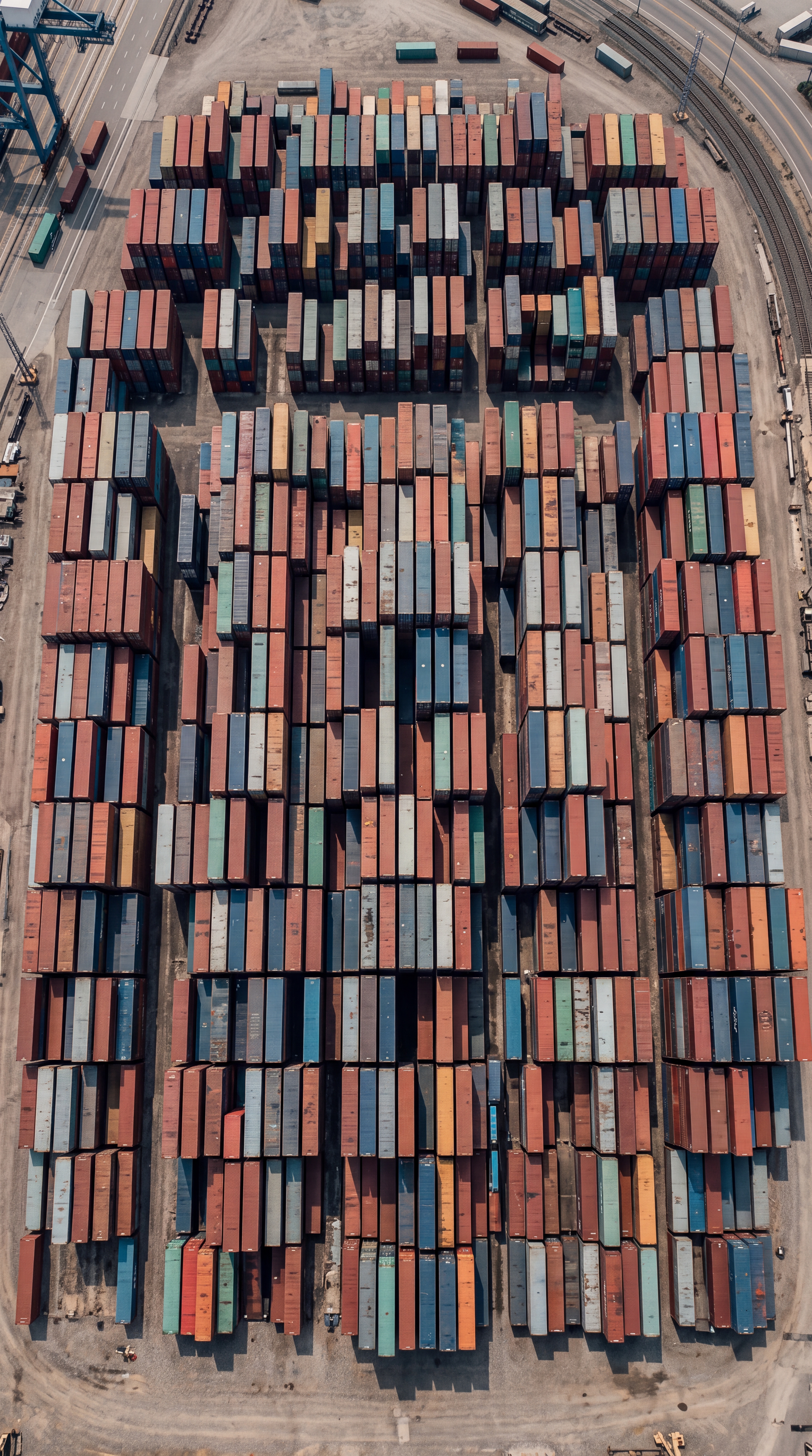 An aerial view of a shipping container yard filled with stacked containers.