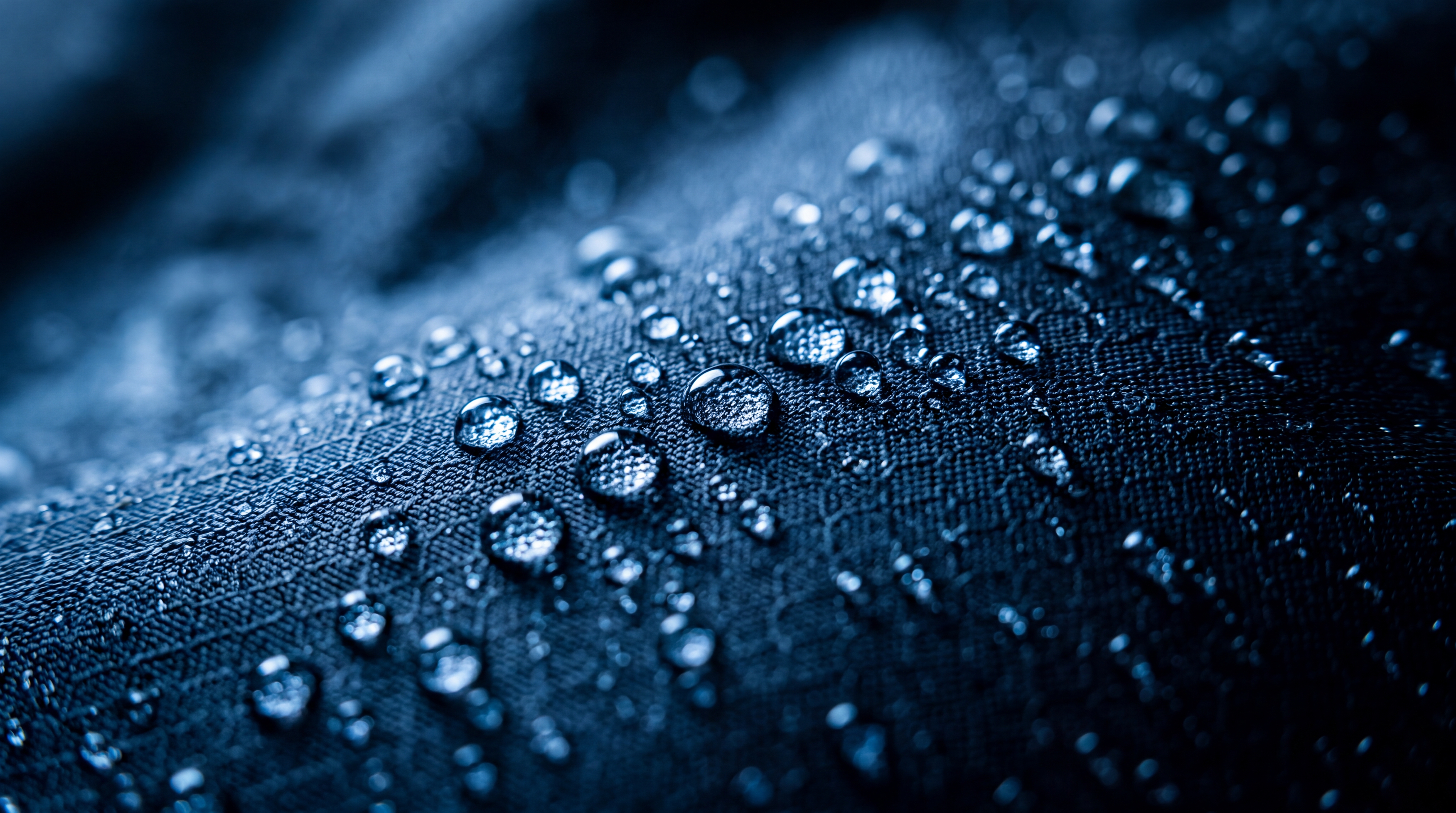 Close-up of water droplets on a textured fabric surface.