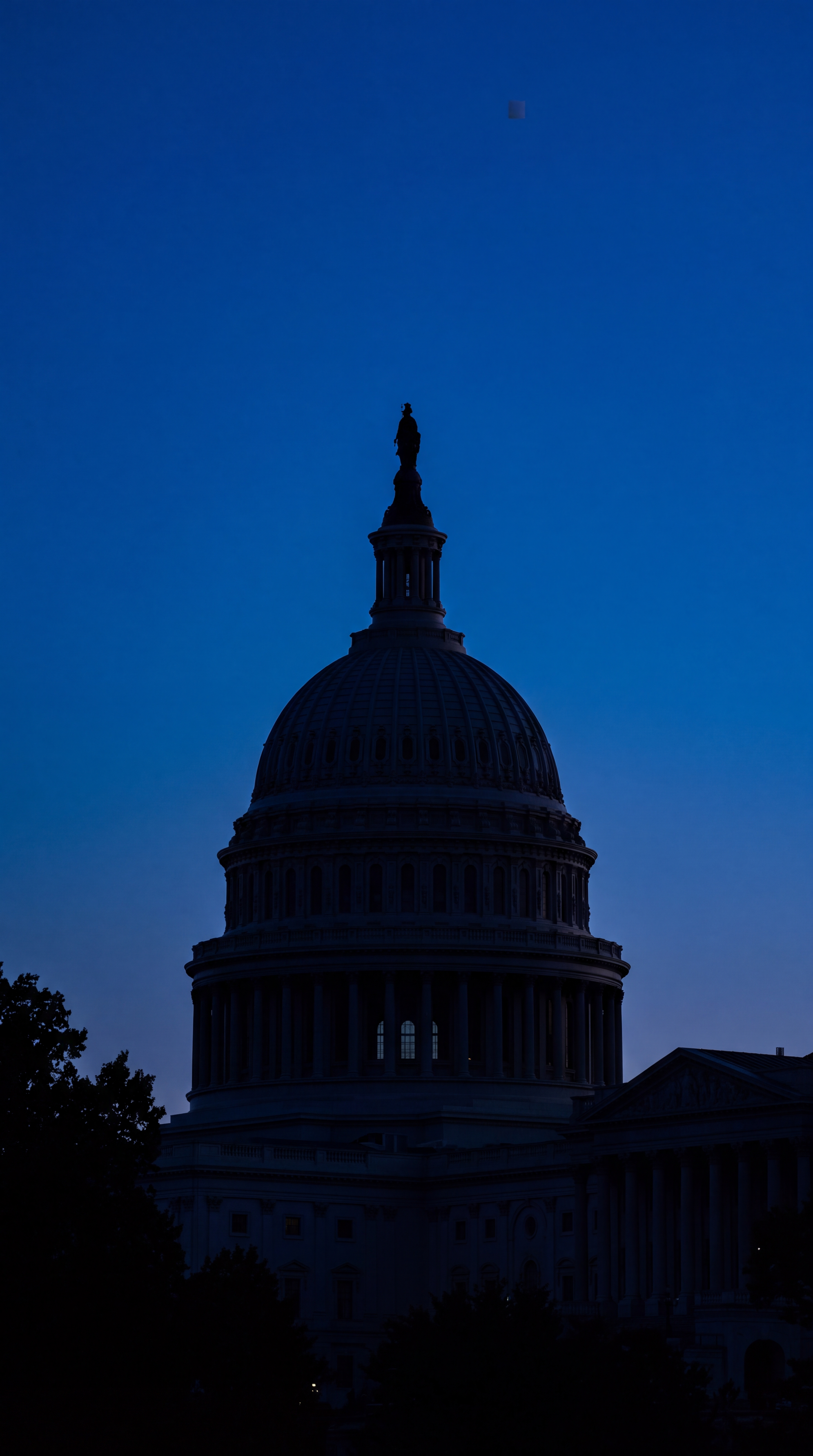 The silhouette of a large dome building against a twilight sky.