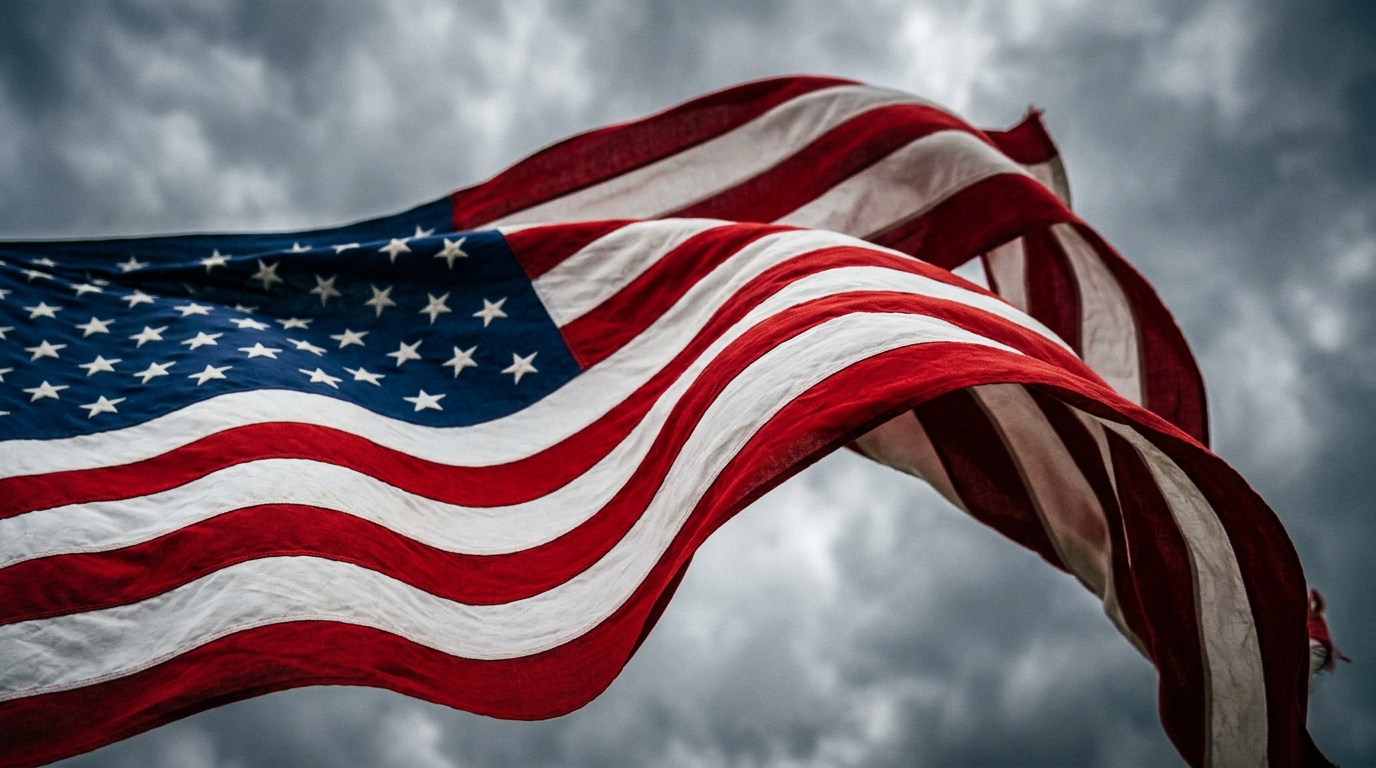 A waving American flag against a cloudy sky.