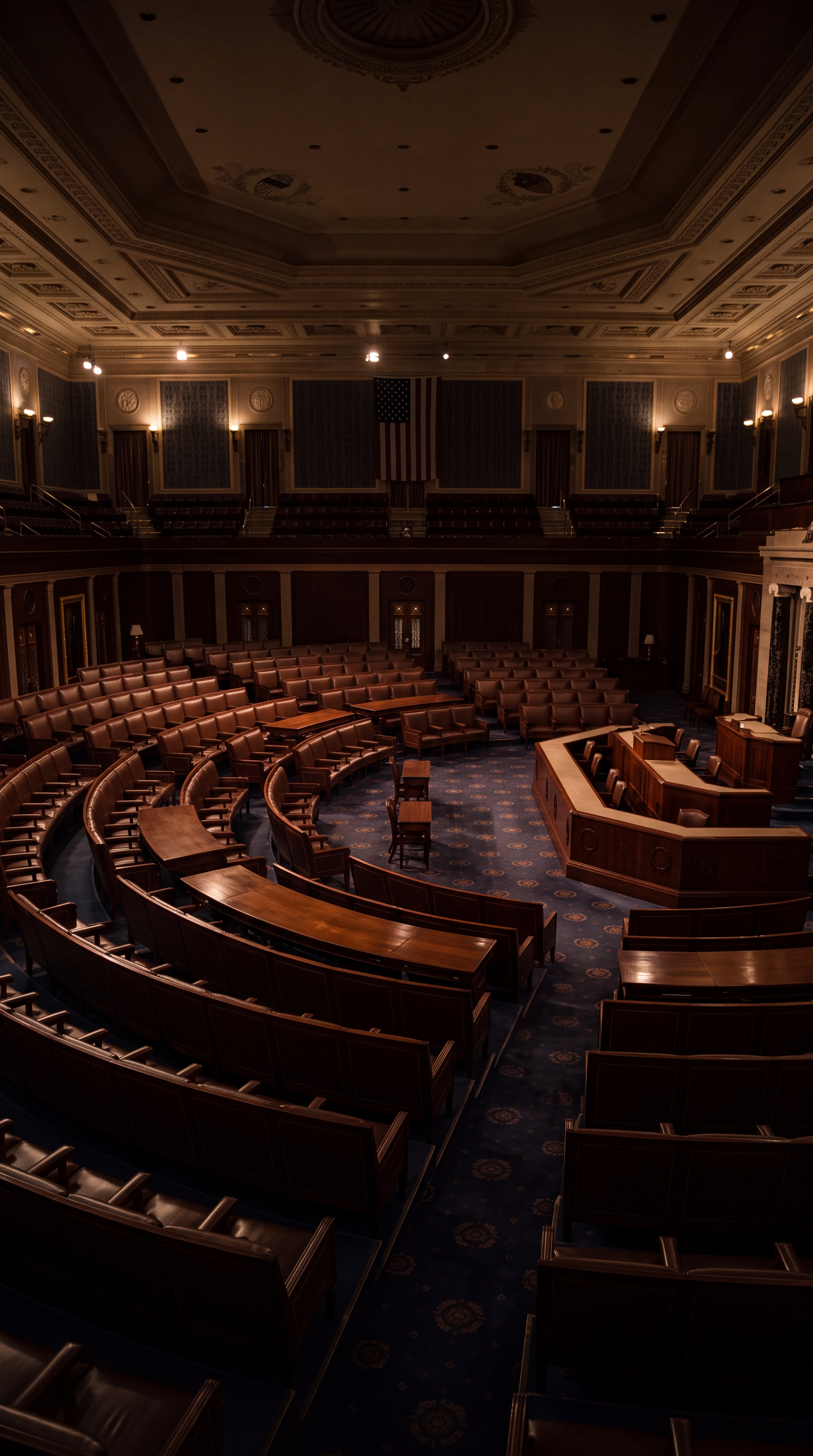 An empty legislative chamber with wooden seating and a podium.