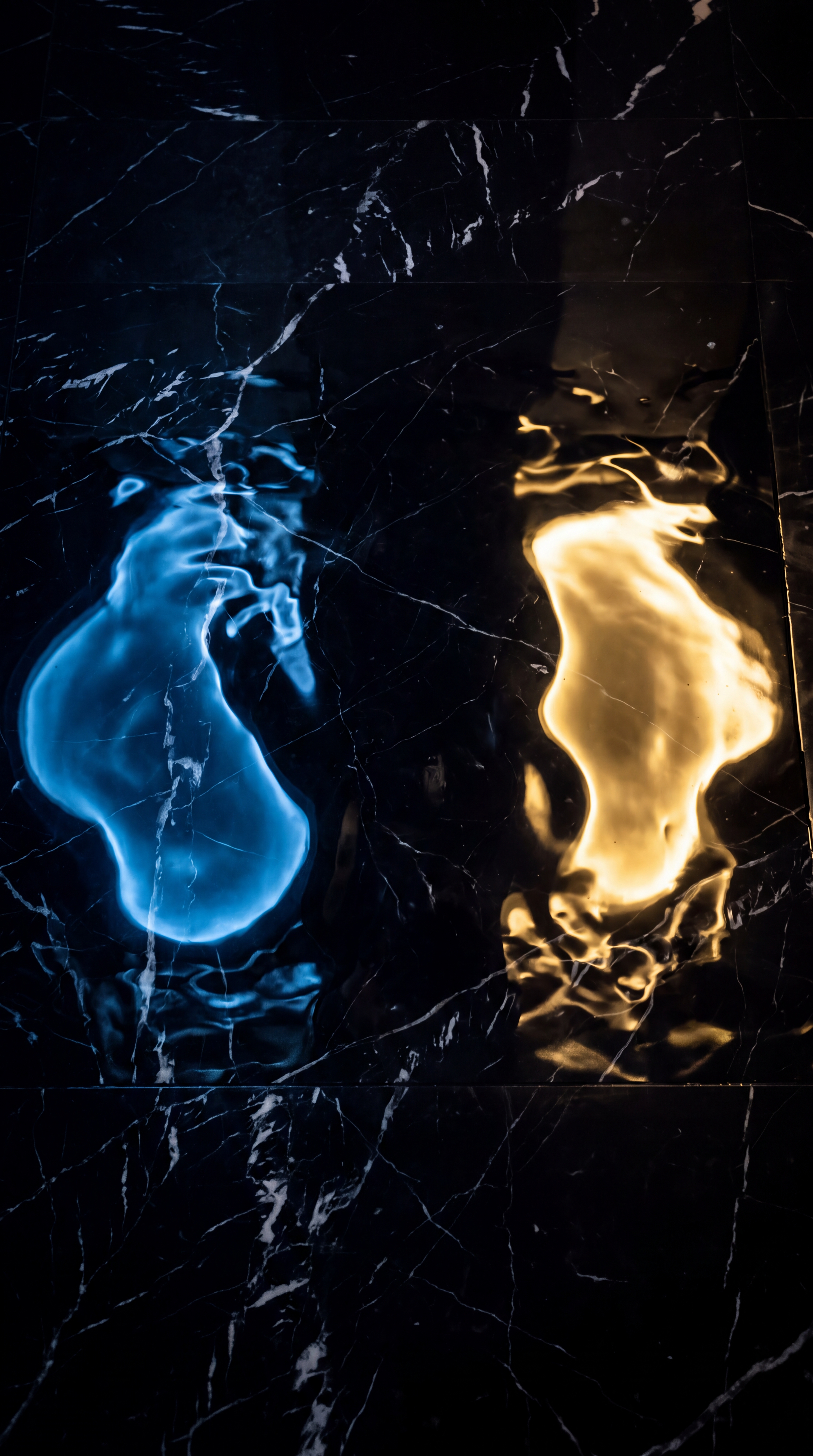 The image features reflections of blue and yellow light on a dark marble surface.